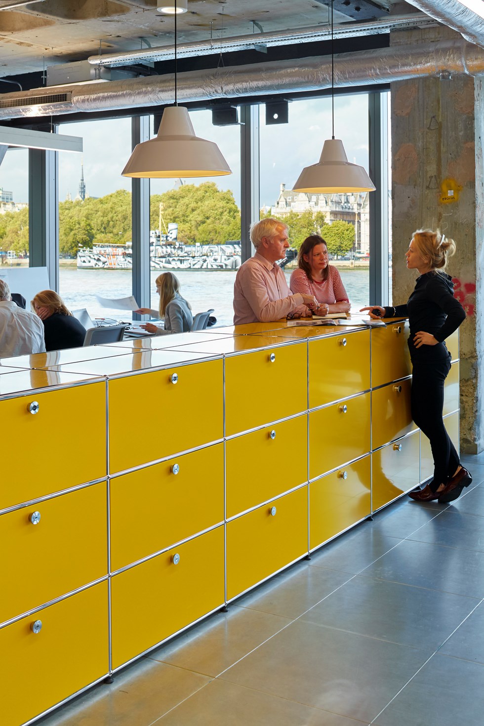 Goldgelbe USM Haller Bürotrennwände mit Schrank Archiv in einem industriell designten Büro