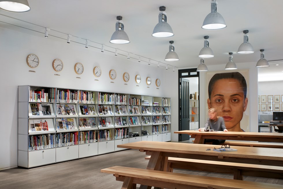 Area relax di un ufficio open space con librerie USM Haller bianche