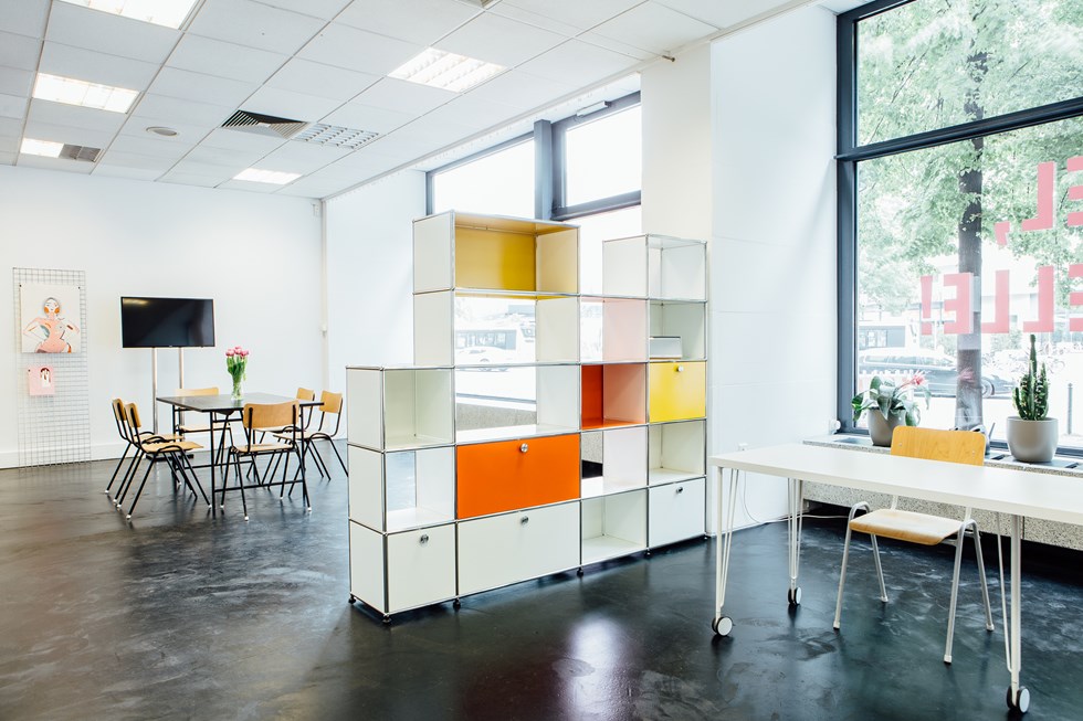 White, yellow and orange USM Haller room divider in a creative office