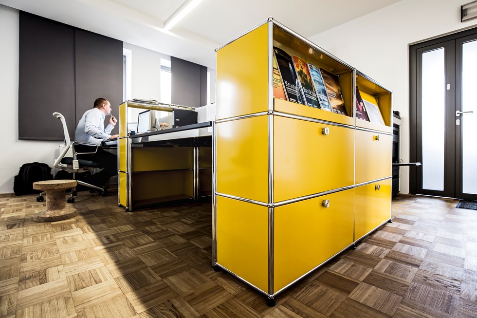 Offen gestalteter Arbeitsplatz mit USM Haller Tischen und gelben Sideboards