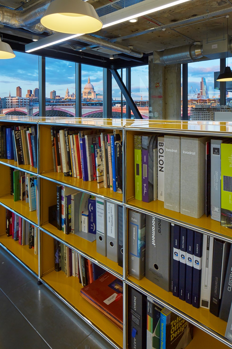 Goldgelbe USM Haller Bücherregale in einem modernen Büro