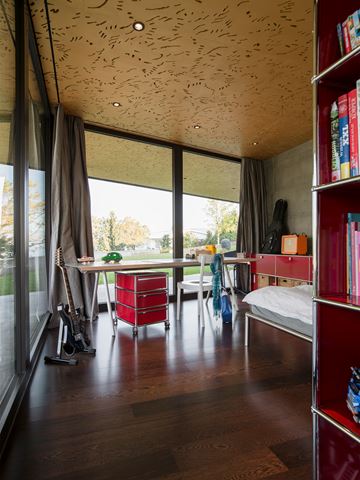 red usm pedestal and bookshelf in a wooden floored kids bedroom