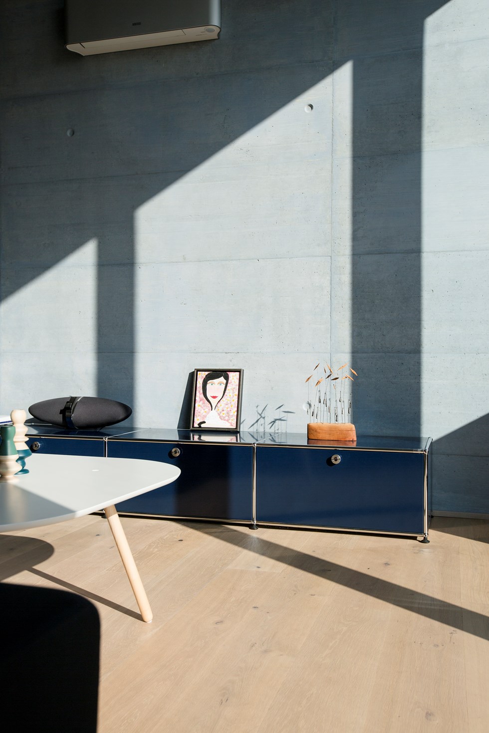 Mobile contenitore in metallo blu USM Haller con elementi cromati in un soggiorno in stile moderno