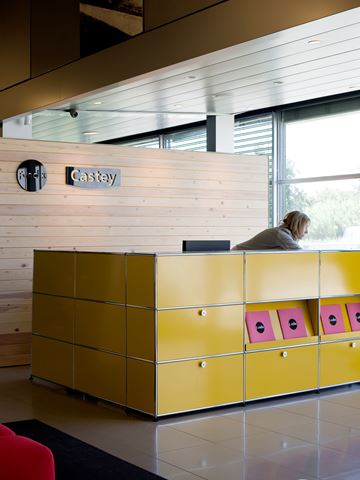 golden yellow USM haller reception desk and storage cabinets in an open plan reception
