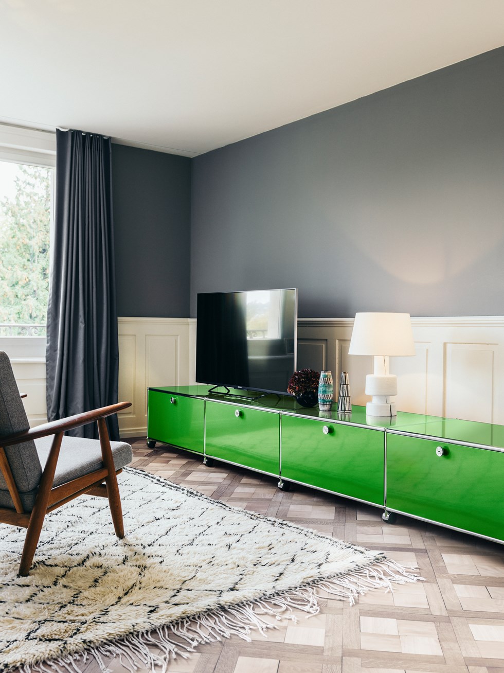 meuble de rangement en métal vert USM Haller avec rangement dans un salon aux murs bleus