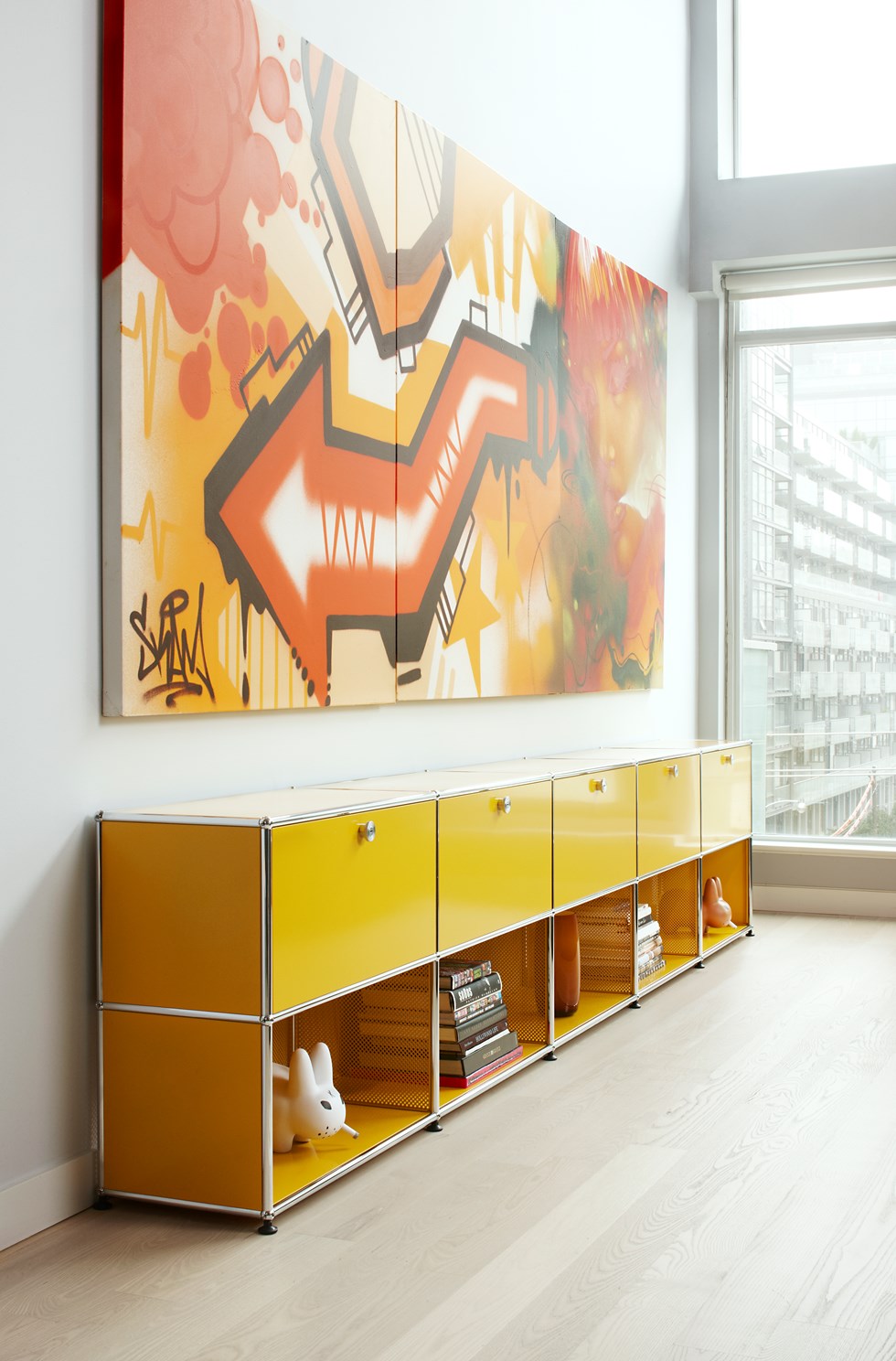 meuble de rangement USM Haller jaune avec étagères et tiroirs dans un salon