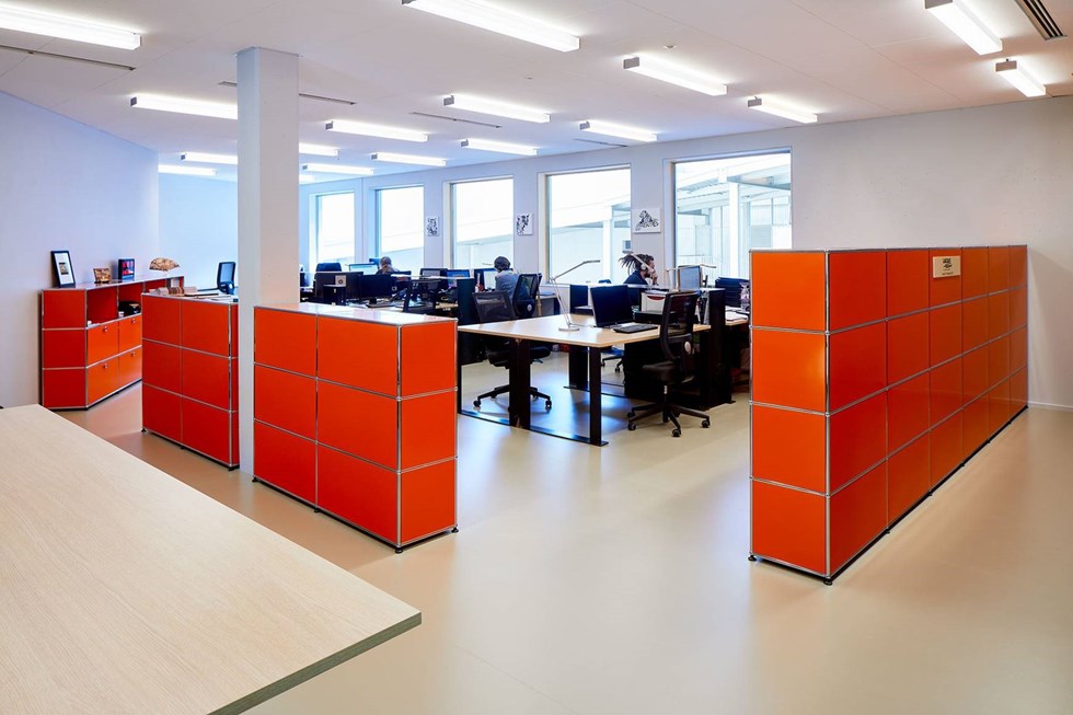 orange and chrome USM haller office partition with storage cabinets in a contemporary office