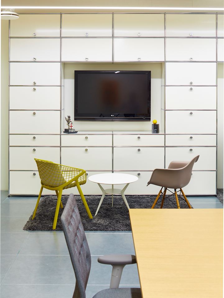 pure white USM haller tv unit with storage cabinets in a an office breakout area
