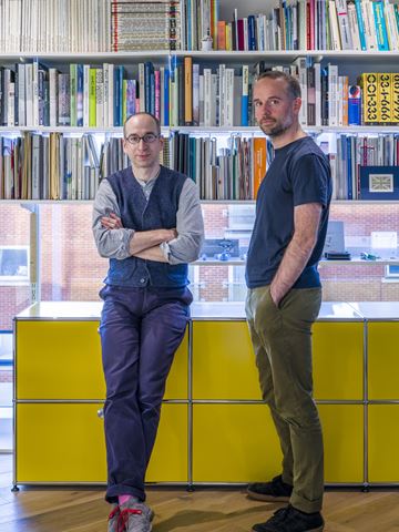 Edward Goodwin and Richard Hartshorn in their modern, open plan office with yellow USM Haller