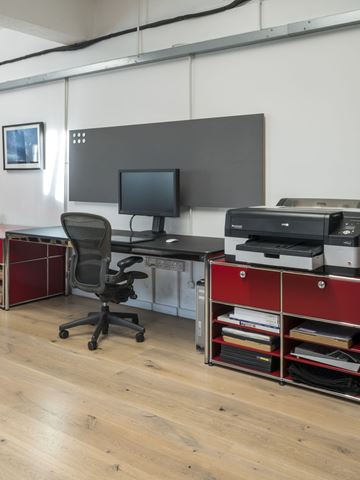 open plan photographic studio with red USM Haller storage and lino USM Haller desk